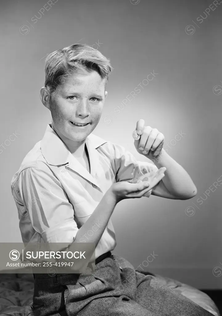 Portrait of boy holding coins and looking at camera