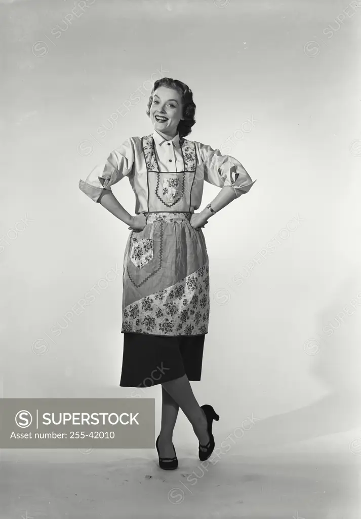 Vintage Photograph. Woman in apron smiling with hands on hips