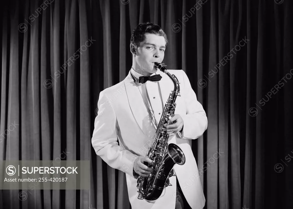 Portrait of young man playing saxophone on stage