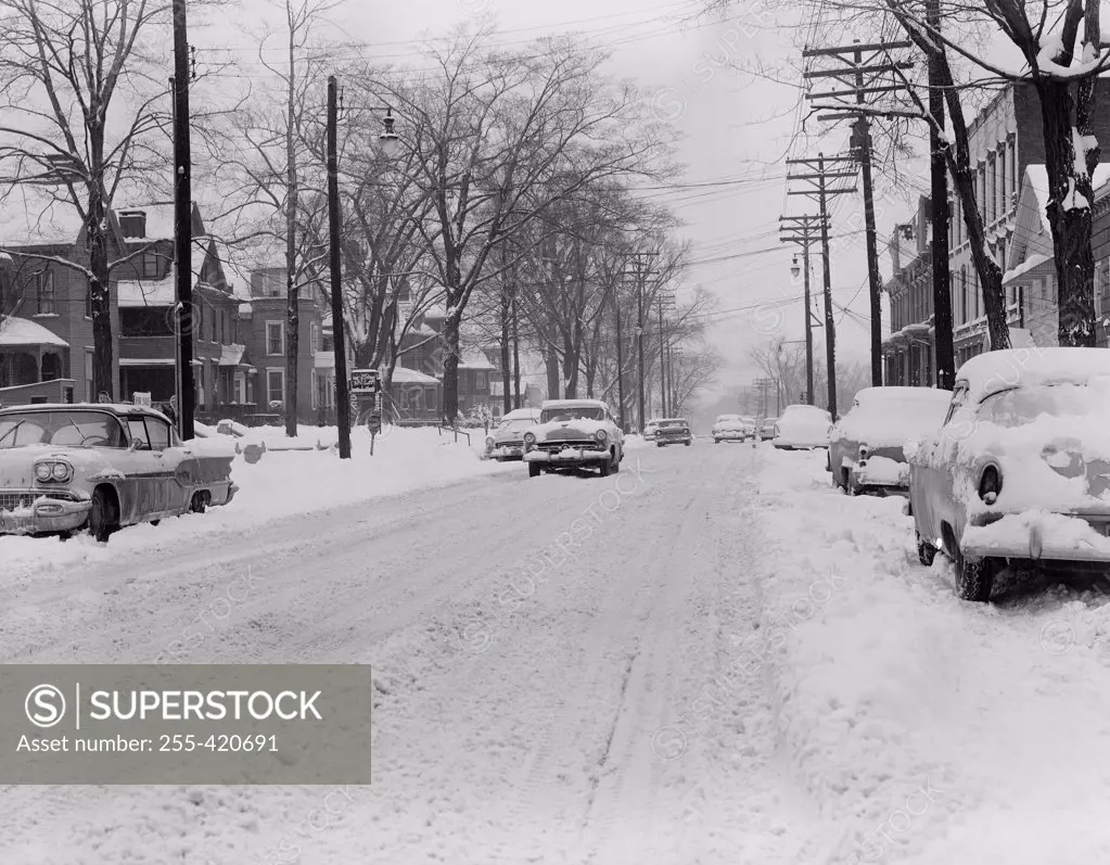 USA, New York, Binghamton, Street covering by snow with cars passing