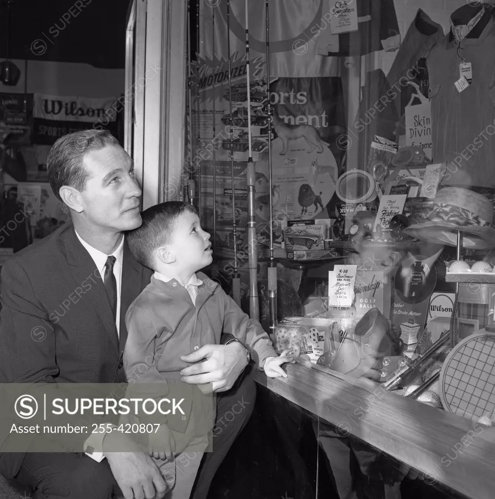Father and son watching window display