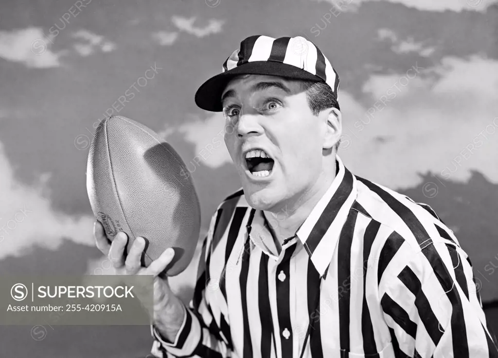 American football referee holding ball