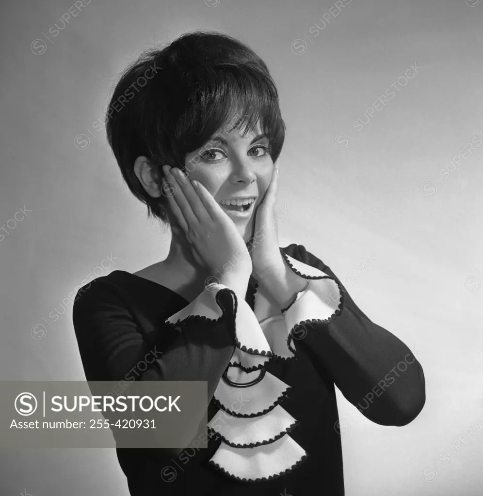 Studio portrait of surprised woman smiling