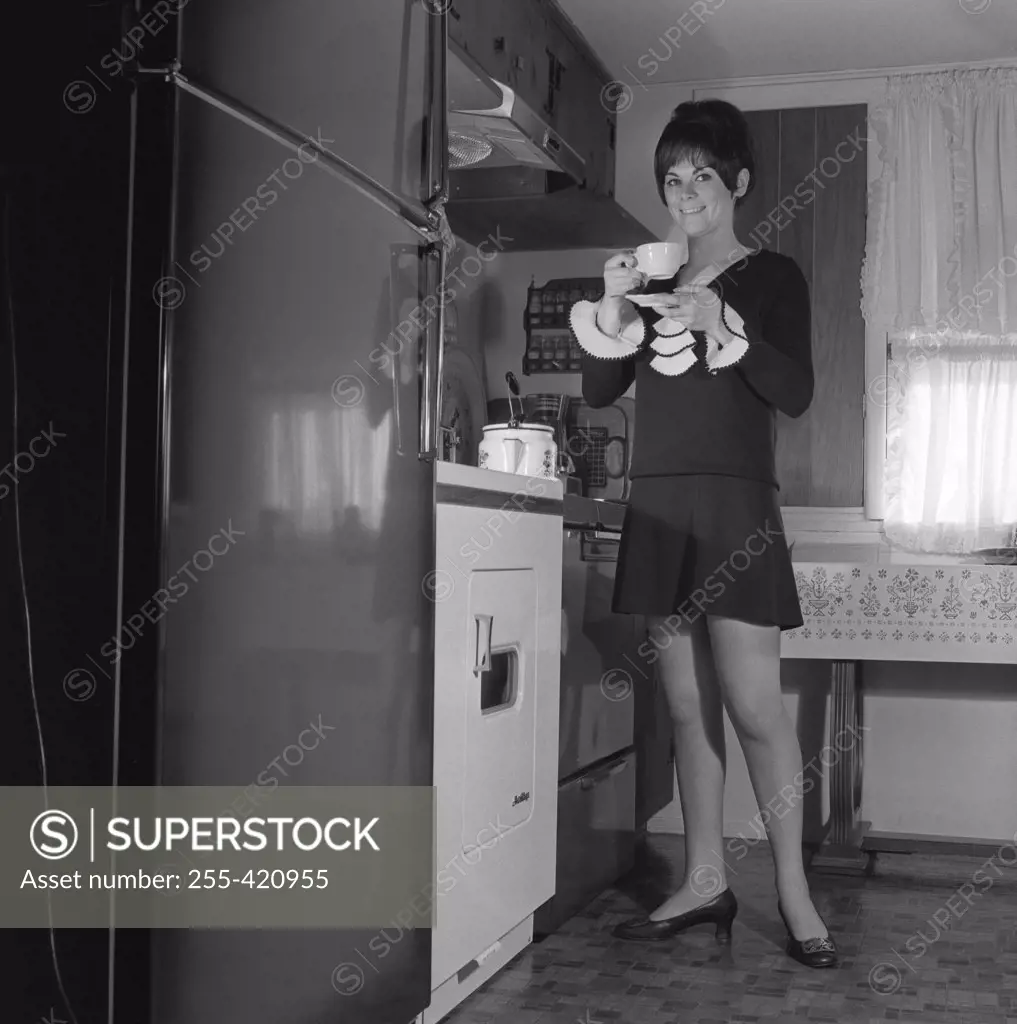 Woman drinking tea in kitchen