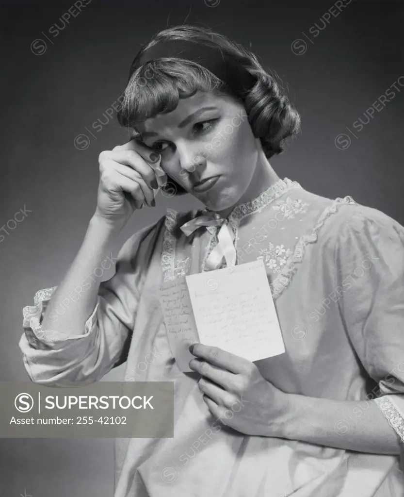 Close-up of a young woman holding a postcard