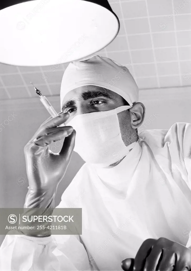 Surgeon holding syringe in operating room