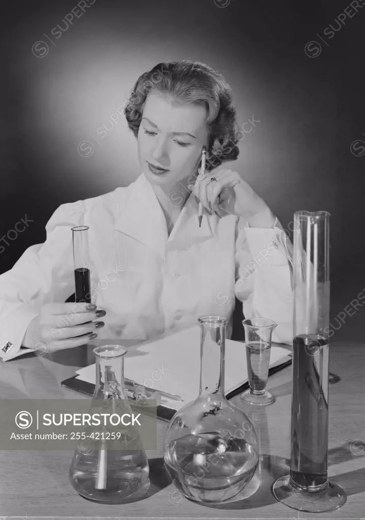 Female scientist examining liquid in test tube