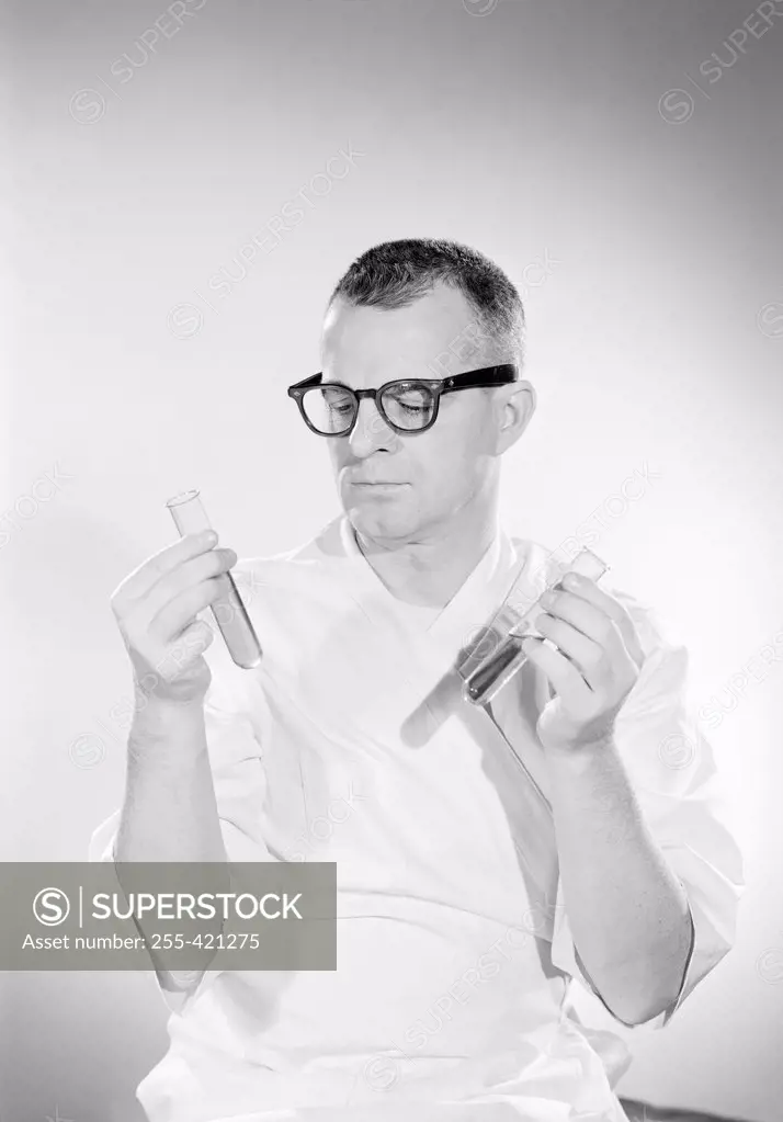Male scientist examining test tubes with liquid