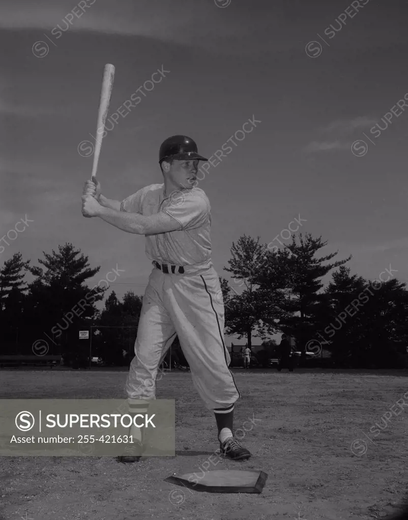 Baseball player holding bat and waiting for ball