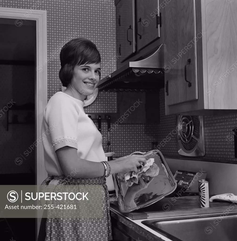 Woman washing dishes and smiling