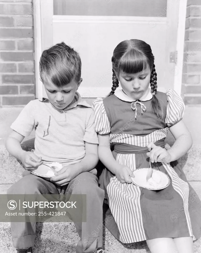 Boy and girl eating ice cream on porch