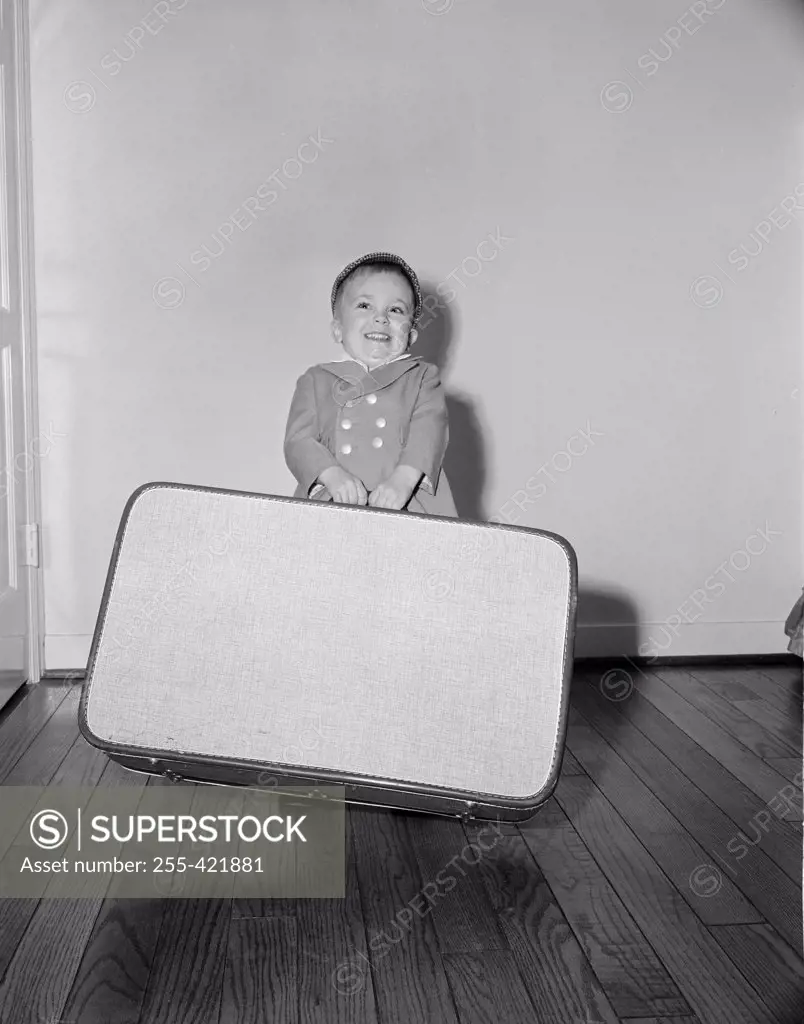 Boy holding large suitcase