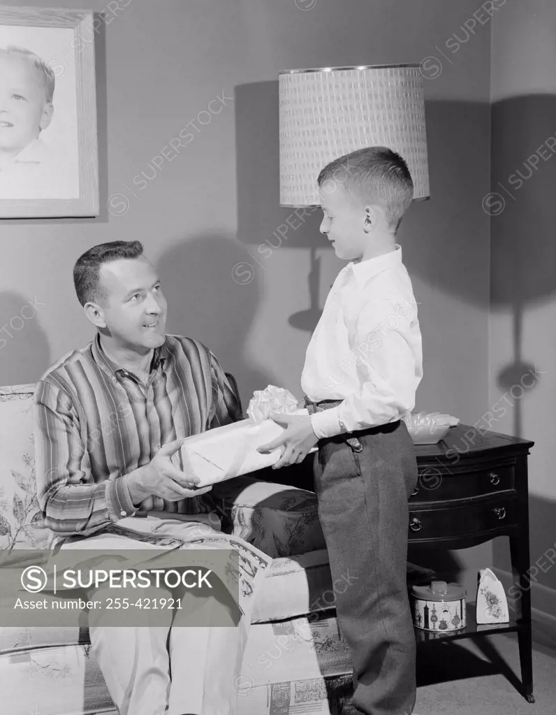 Boy giving gift to father