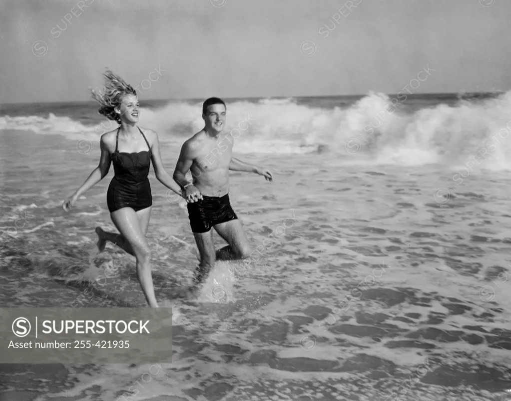 Young couple running in sea