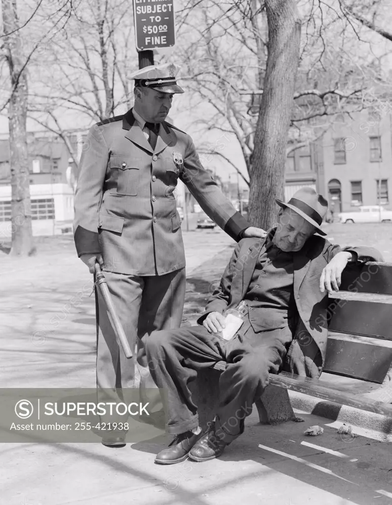Policeman and drunk man on bench