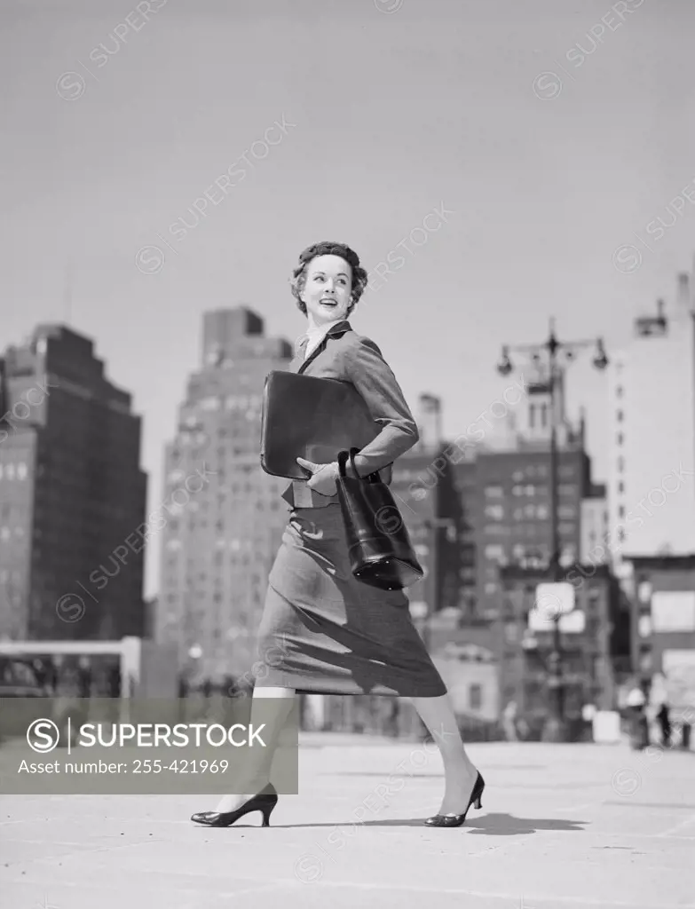Cheerful businesswoman walking in downtown