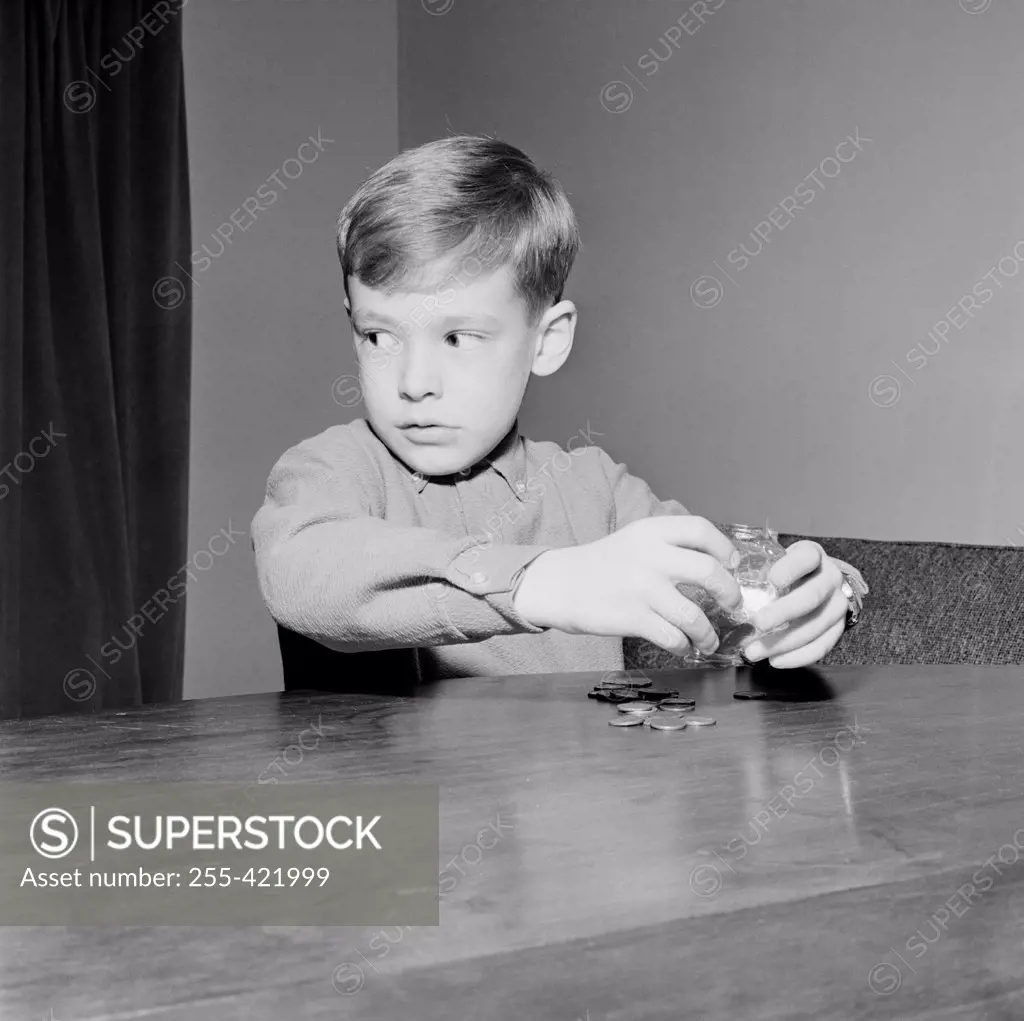 Young boy putting coins in piggybank