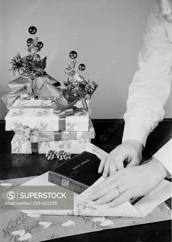 Man wrapping bible as Christmas gift