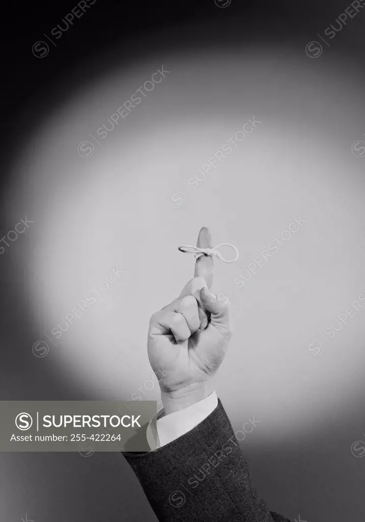 Hand with string tied around finger serving as reminder