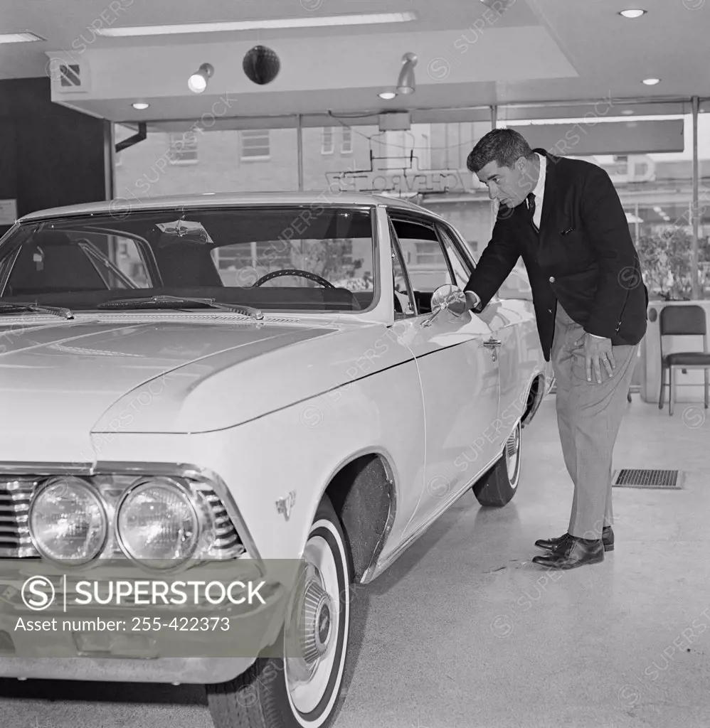Man examining new car in salesroom