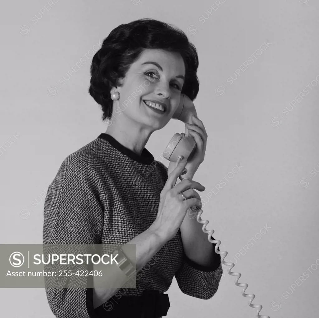 Studio portrait of woman talking on phone