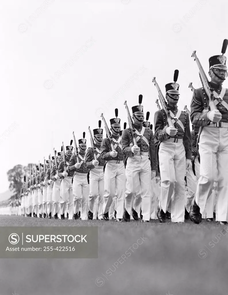 Soldierswearing military uniforms marching in parade formation