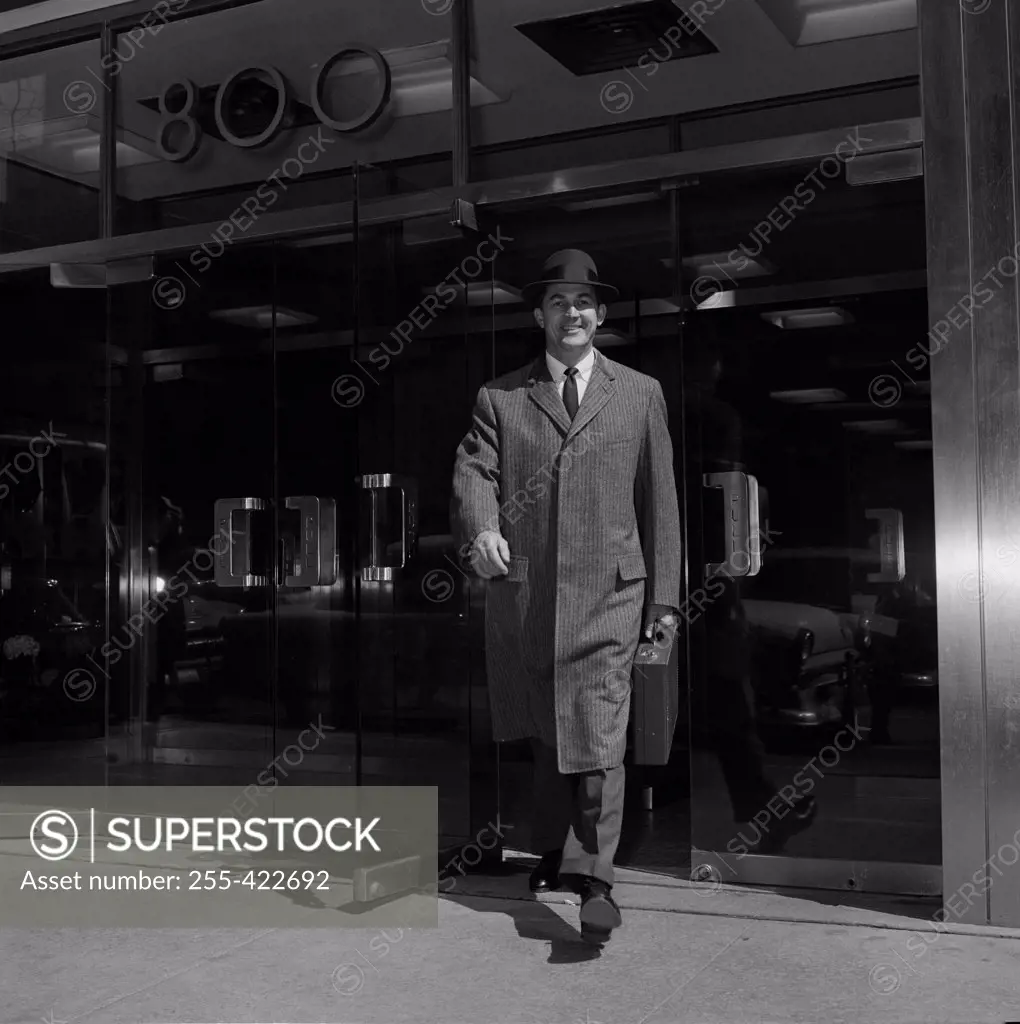 Businessman walking out of office building