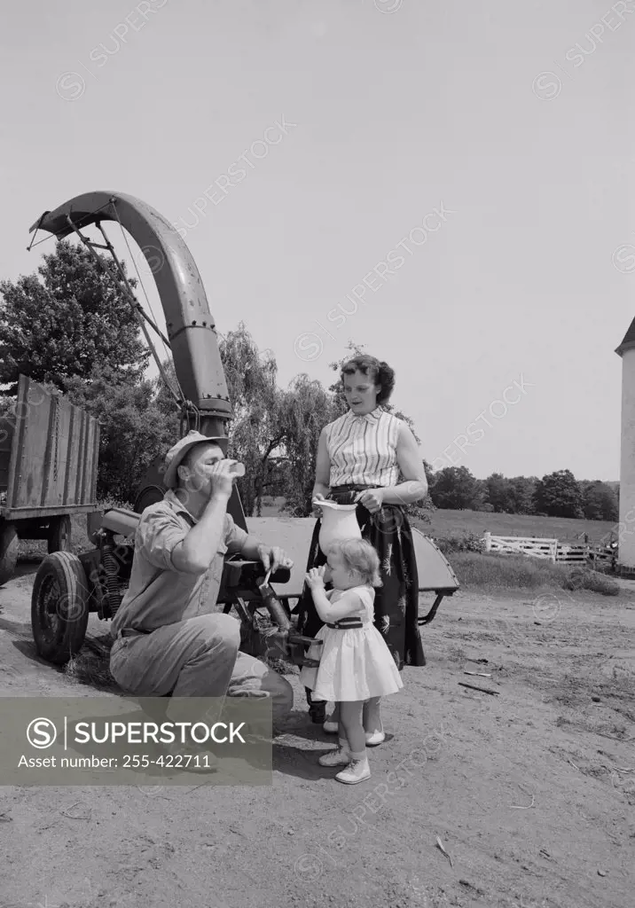 Parents with daughter drinking milk on farm