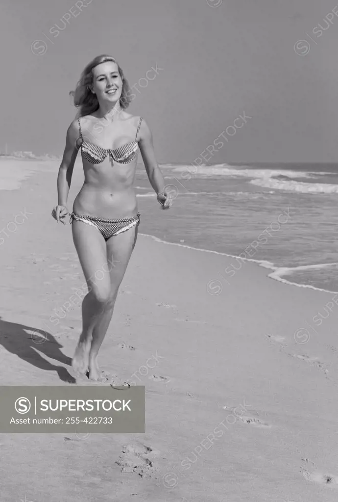Young woman in bikini walking on beach