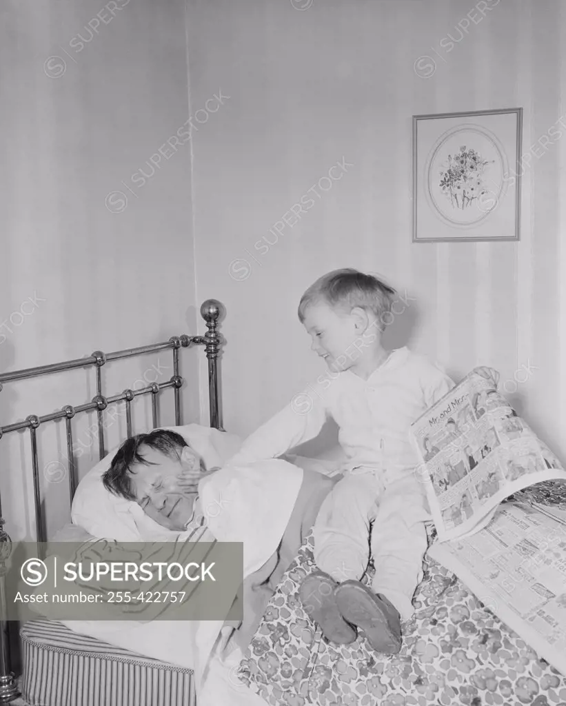 Boy waking father in bedroom
