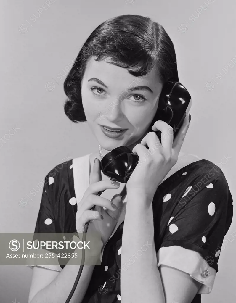Studio portrait of young woman talking on phone