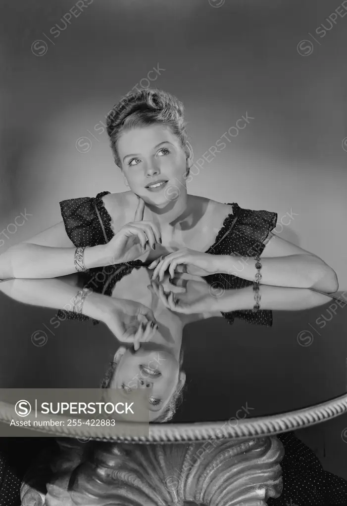 Studio shot of young woman sitting in chair
