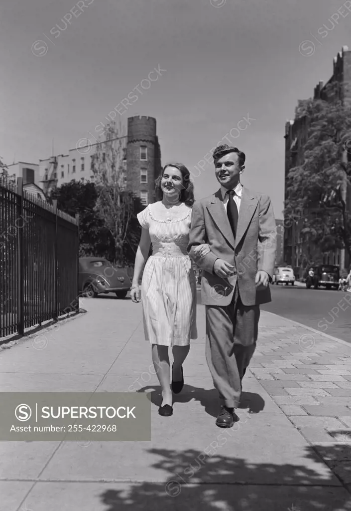 Young couple walking arm in arm in street