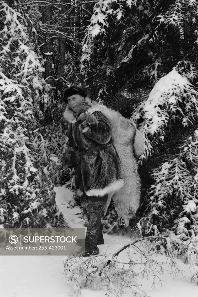 Trapper carrying dead wolf