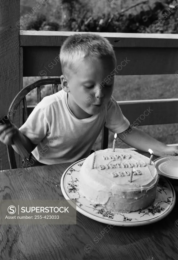 Boy blowing candle on birthday cake