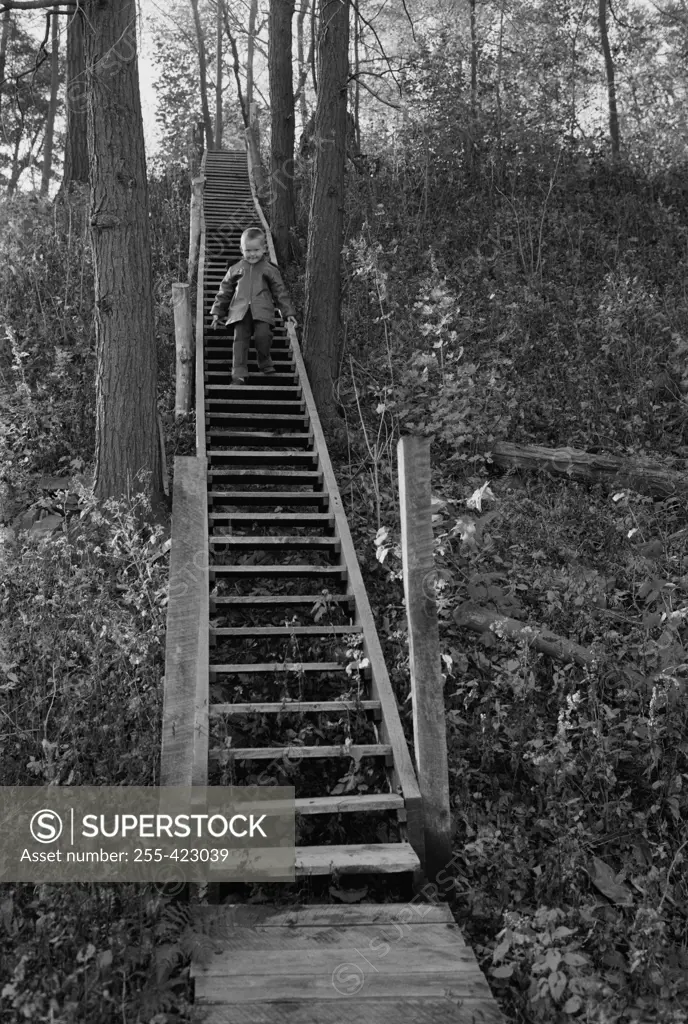 Boy walking on wooden steps outdoors