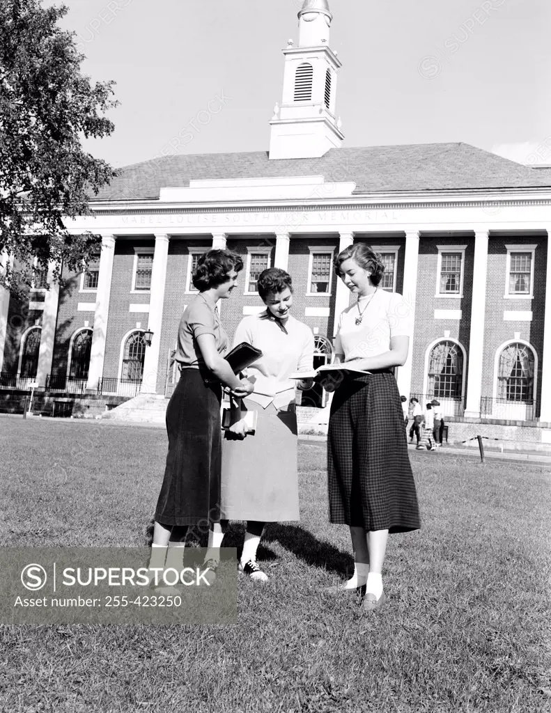 USA, Vermont, Burlington, University of Vermont, Three young girls standing and reading books