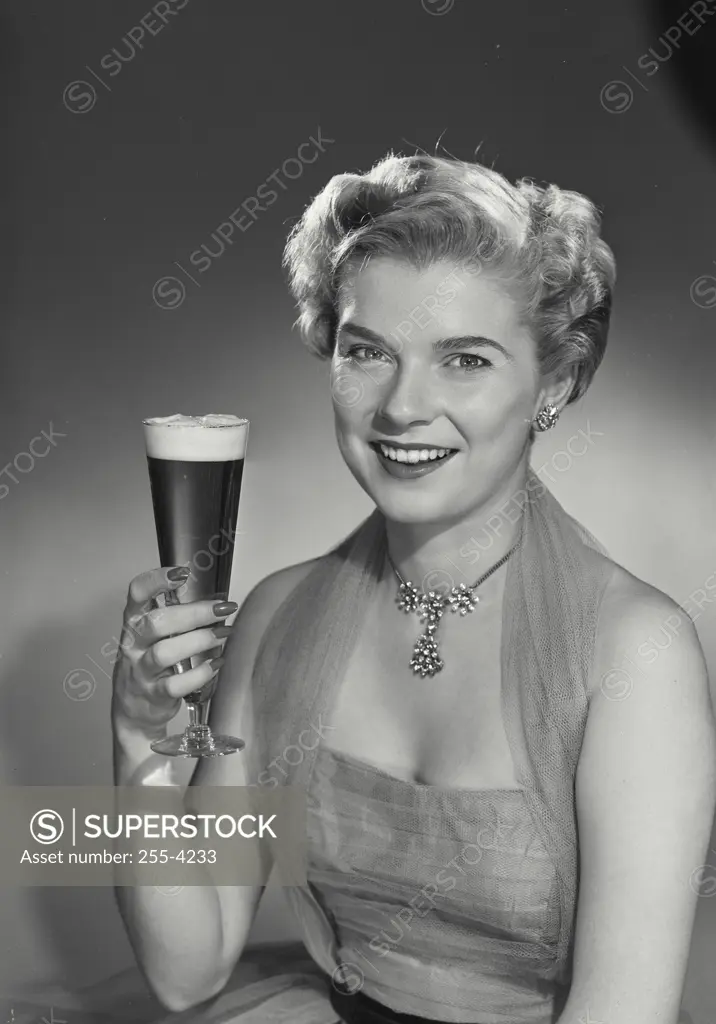 Vintage Photograph. Woman in lace dress holding glass of beer.