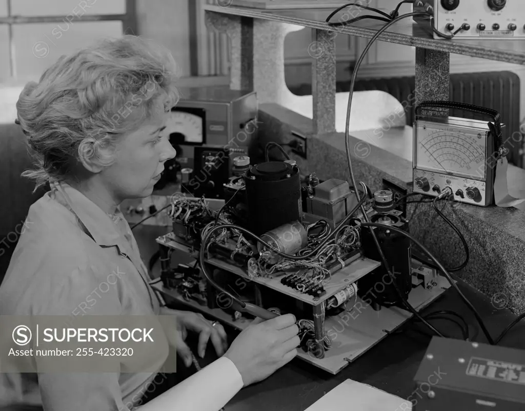 Female worker testing electronic component