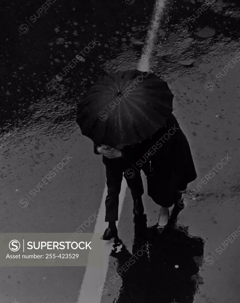 Elevated view of people walking under umbrella in rain