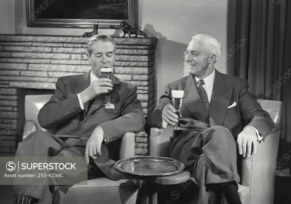 Vintage Photograph. Men in suits sitting in chairs talking and having beers