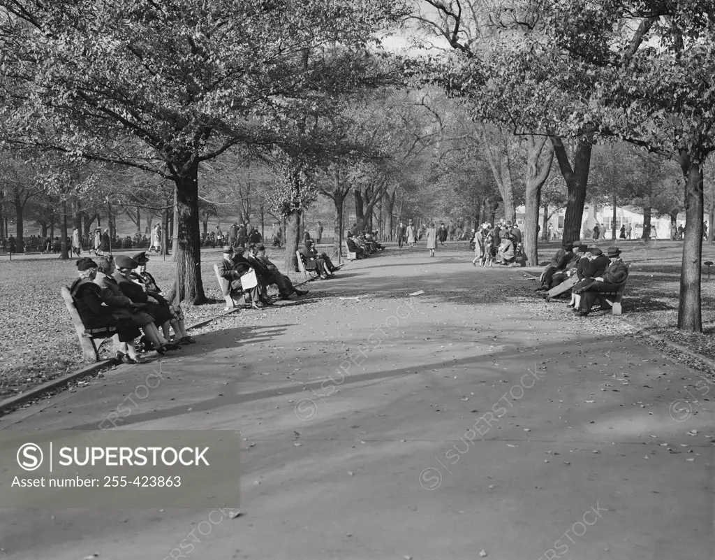 USA, Massachusetts, Boston, People sitting on benches and walking in park