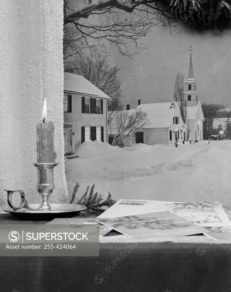 USA, Vermont, Waterford, Christmas candle and greeting cards on window sill, church in background