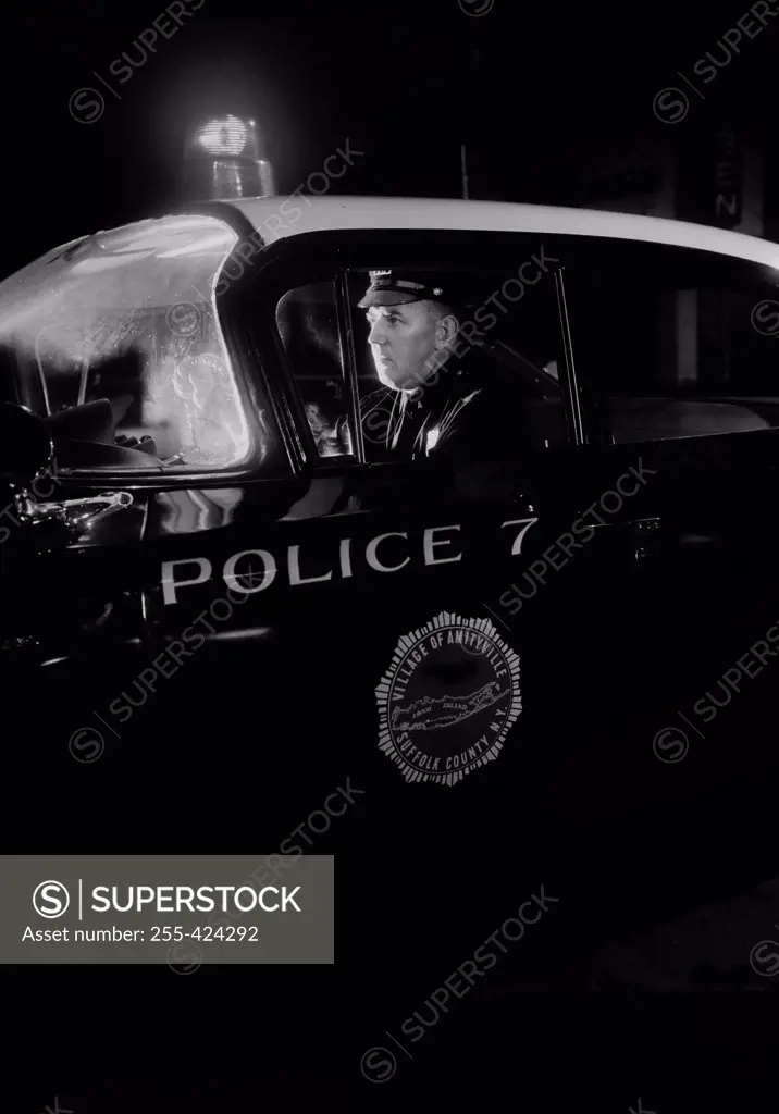 Policeman in patrol car at night
