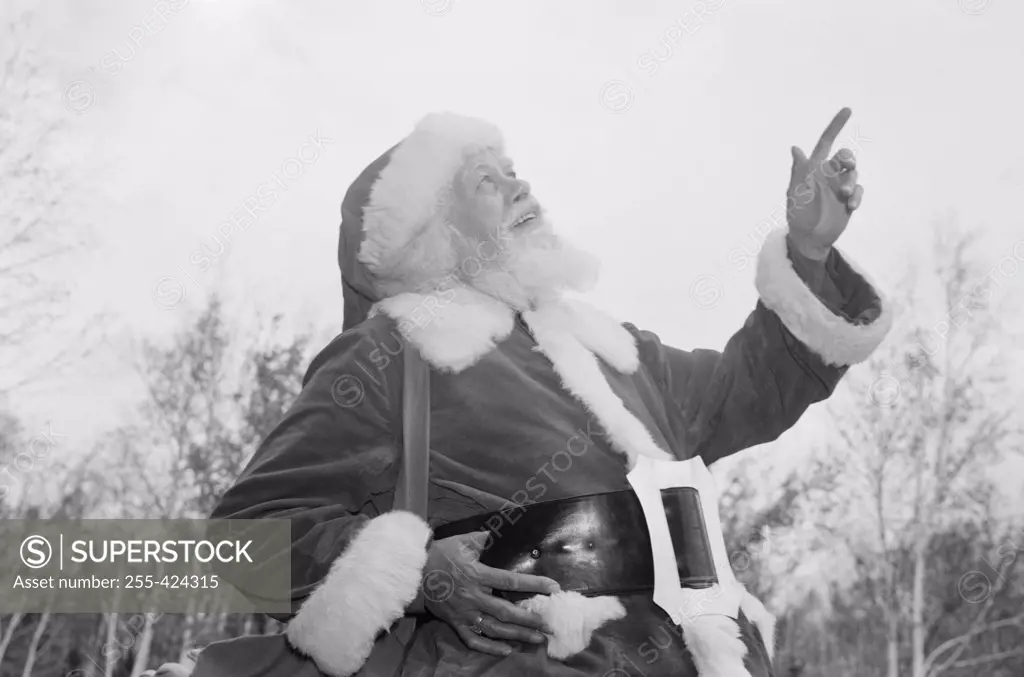 Father christmas pointing up at sky