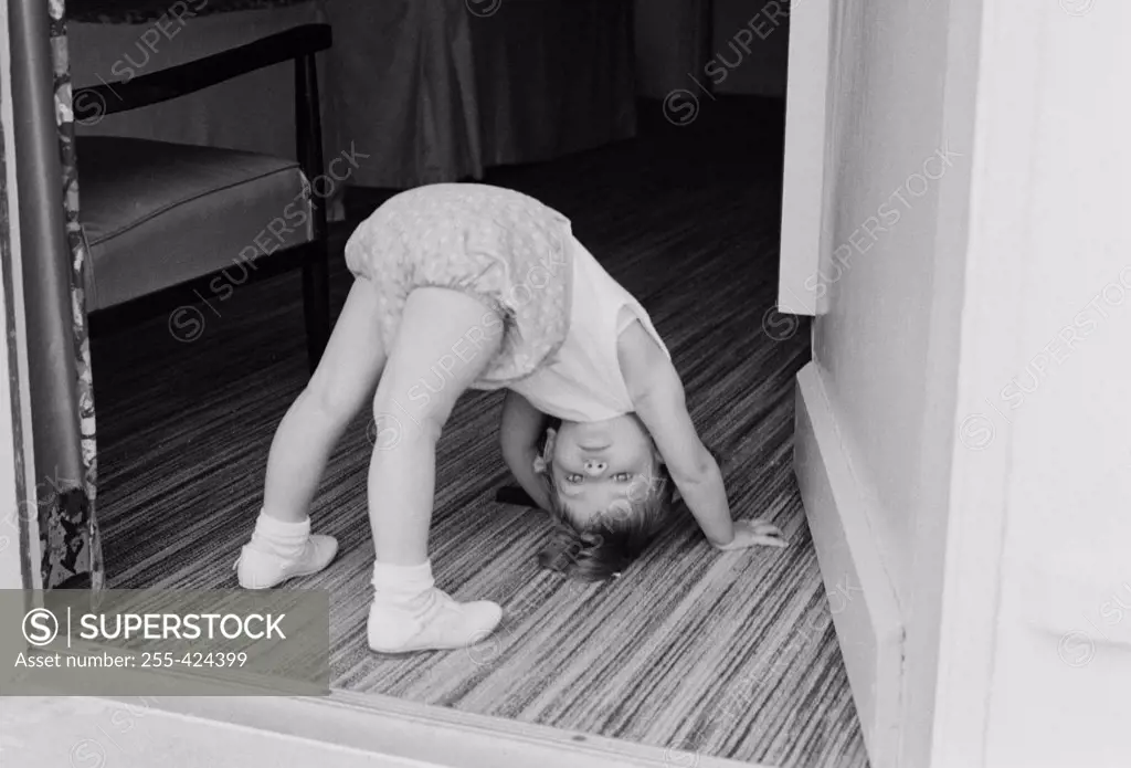 Little girl exercising in doorway