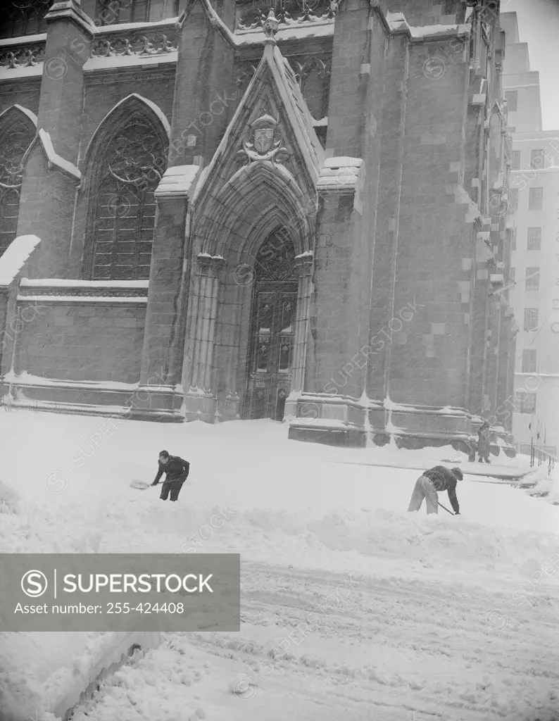 USA, New York City, St. Patrick's Cathedral, workers shoveling snow