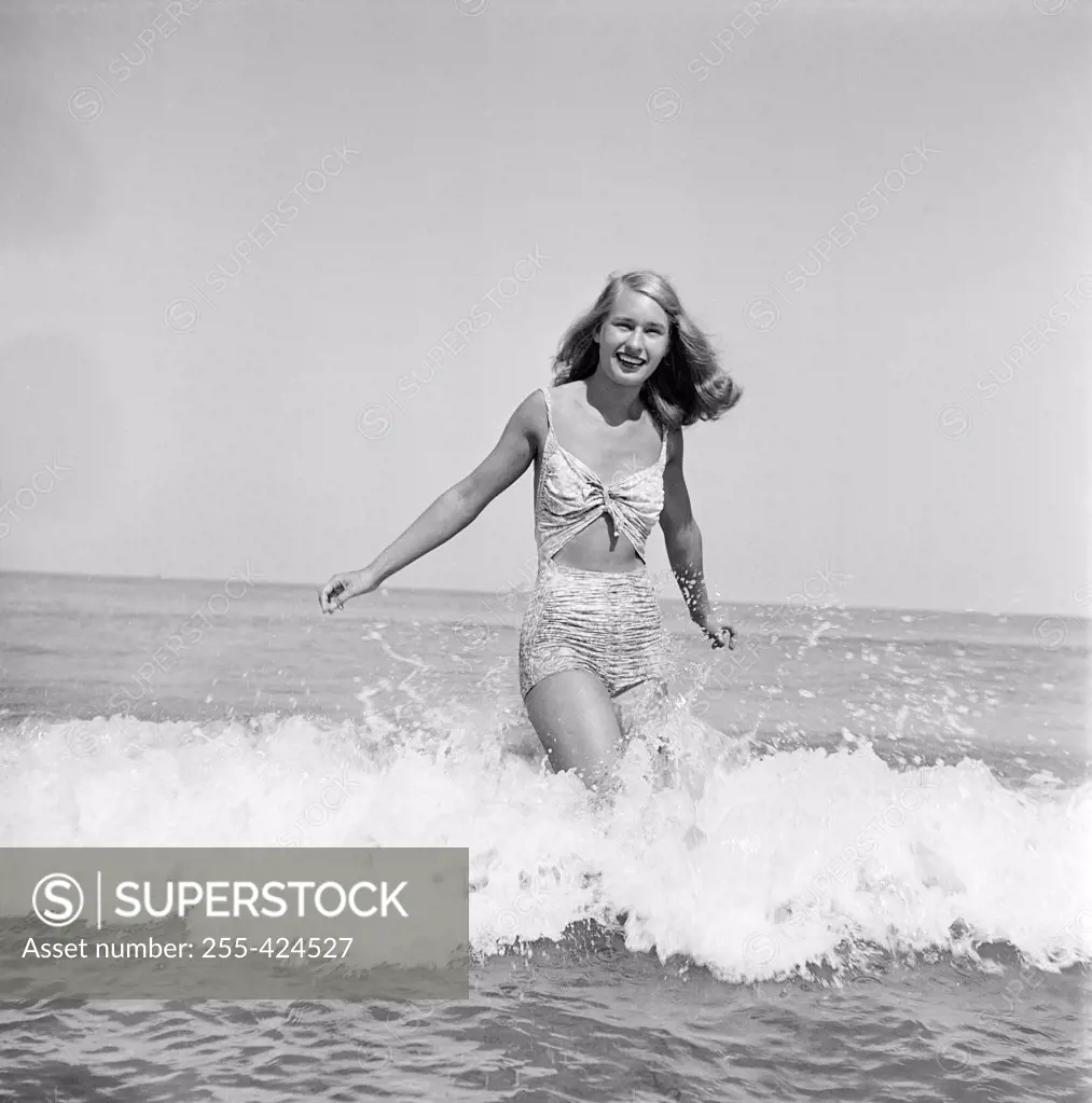 Young woman wearing bikini wading in sea