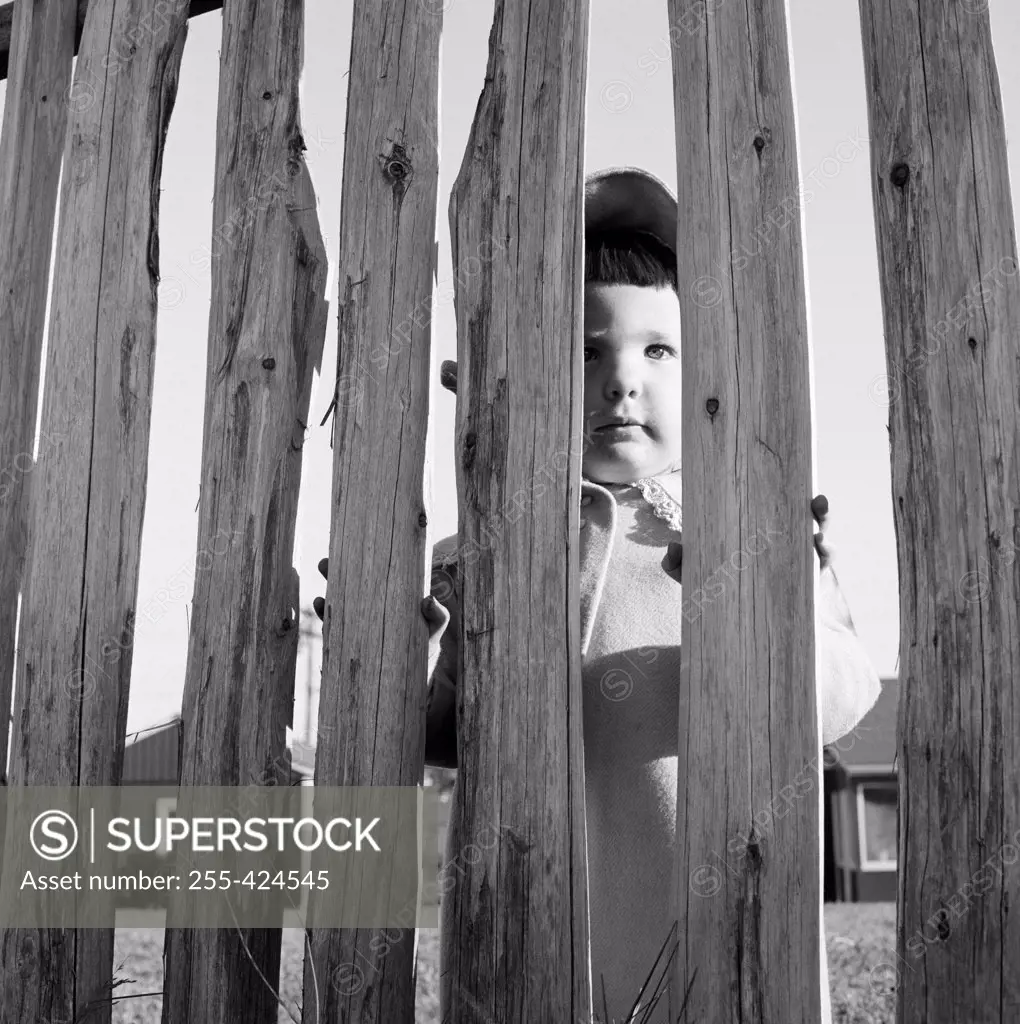 Girl looking through fence