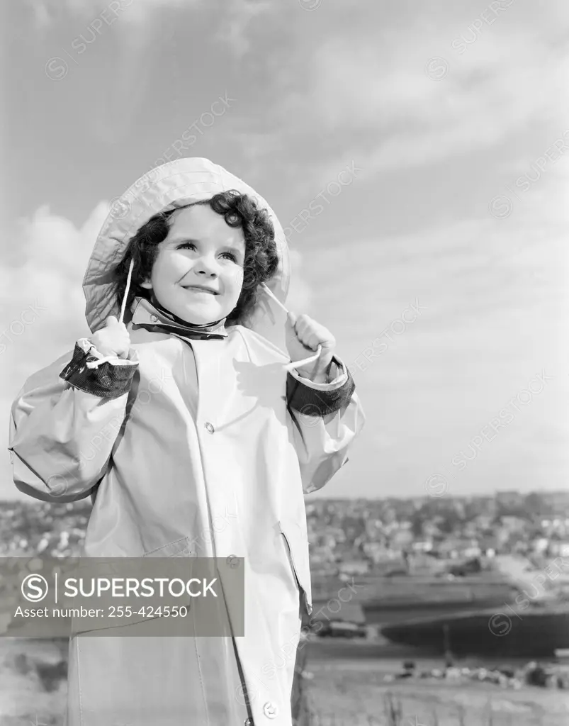 Girl wearing raincoat looking away and smiling
